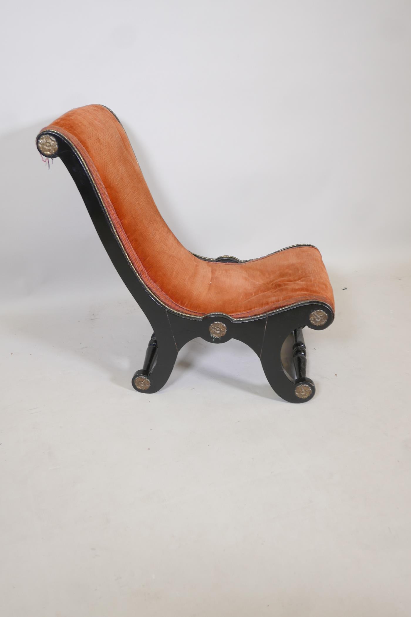 A Victorian ebonised slipper chair, with rust red upholstery and brass decorative motifs and trim, - Image 2 of 3
