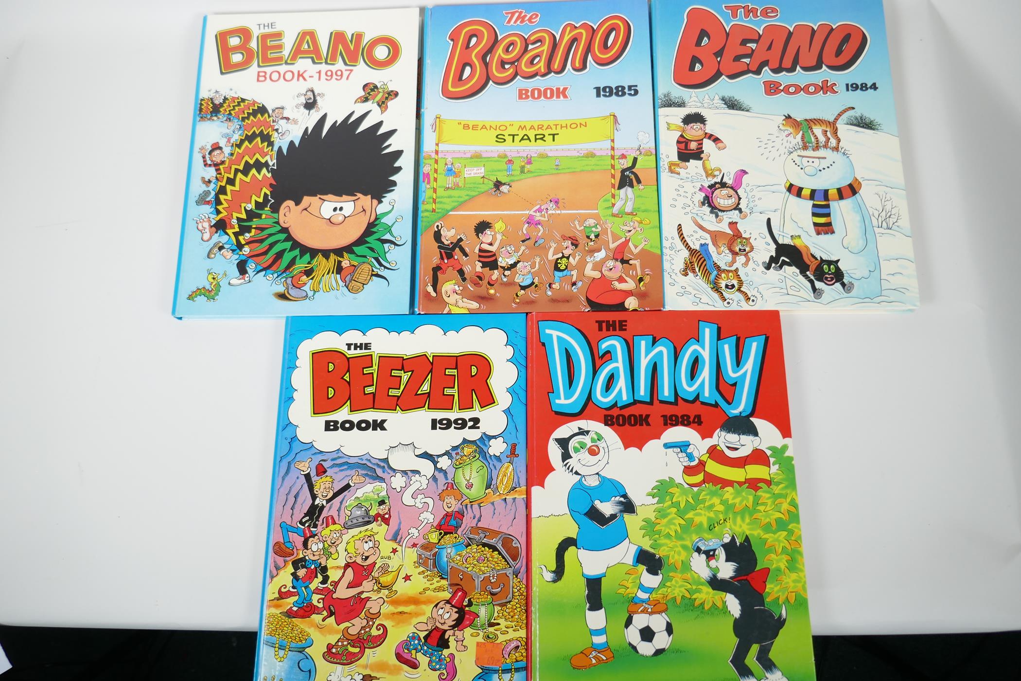 Four children's annuals, The Dandy 1984, The Beano 1984-85 and 1997, and The Beezer 1992