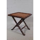 A hardwood occasional table carved in the form of bamboo, with a leather top, 20" x 20", 20" high
