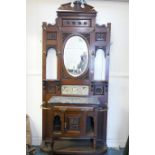 A Victorian walnut hall stand, with broken pediment top over an oval mirror with all over carved