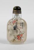 A Chinese reverse decorated glass snuff bottle depicting birds perched on branches in bloom, 3" high