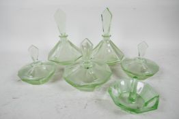 An Art Deco green glass dressing table set of octagonal form comprising two perfume bottles, three