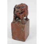 An antique Chinese carved soapstone figure of a kylin standing on a square pedestal, A/F, 5" high