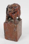 An antique Chinese carved soapstone figure of a kylin standing on a square pedestal, A/F, 5" high