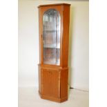 A contemporary teak illuminated corner display cabinet with single cut glass door, and mirror