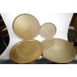 Four Islamic brass trays, all with engraved decoration, largest 26" diameter