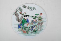 A Chinese famille verte porcelain circular plaque decorated with women and children in a