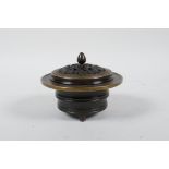 A Chinese bronze censer and cover on tripod feet, the pierced cover with bat and auspicious symbol