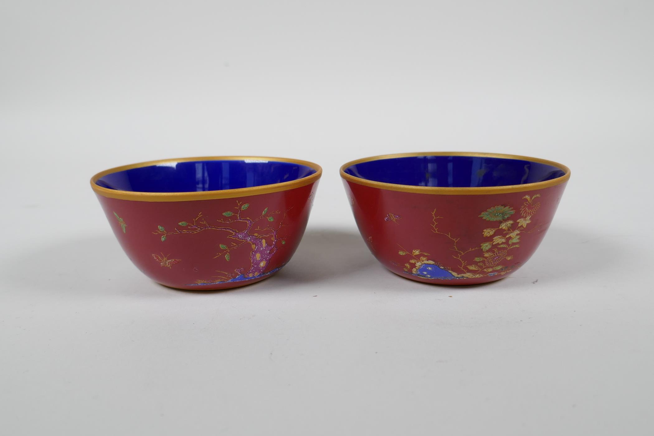 A pair of Chinese red ground porcelain tea bowls with polychrome decoration of flowers, foliage - Image 2 of 5