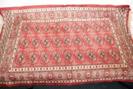 A small Bokhara pattern red ground rug, 44" x 26"
