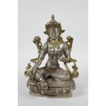 A Sino-Tibetan silvered metal deity seated on a lotus throne, 8" high