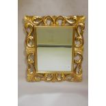 A carved giltwood Florentine style wall mirror with bevelled glass, mid C20th, 25" x 30"