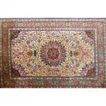 A Persian silk rug with floral medallion design on a white ground, 40" x 61"