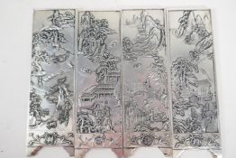 A set of four Chinese white metal scroll weights in the form of screen panels embossed with