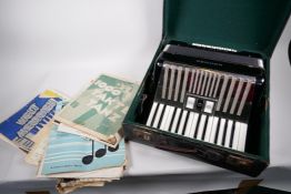 A Hohner student IVM piano accordion, 12½" wide, in fitted case with a quantity of sheet music