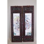A pair of Chinese porcelain plaques with enamel decoration, mounted in carved and pierced hardwood