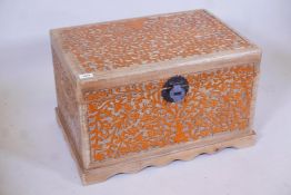 An Indian carved wooden trunk decorated with a flowering tree, the carving with coppered enhanced