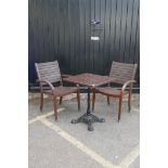 Two teak garden elbow chairs and a wrought iron and plastic bistro table, 23" x 23", 29" high