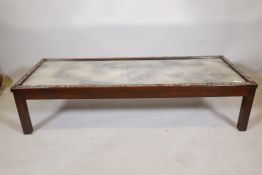 A Chinese hardwood low table, inlaid with mother of pearl decoration, and inset with antiqued mirror