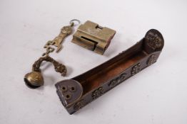 An Oriental brass padlock, an Indian bronze bell in the form of a head and a Tibetan copper