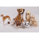 A collection of dog figurines, including three Sylvac sad spaniels, an Italian Boxer puppy, 8" high,