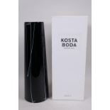 A tall Swedish Kosta Boda tapered cylindrical vase with white cut decoration on a black body, 13"