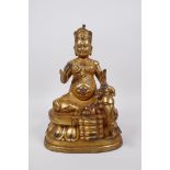 A Tibetan gilt bronze of a deity seated on a lotus throne accompanied by a rat, 10" high