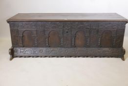 An C18th Italian oak cassone, with carved frieze and four arched panel front, initialled and dated