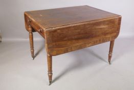 A Georgian mahogany drop leaf table with rosewood banded top and single end drawer, raised on ring