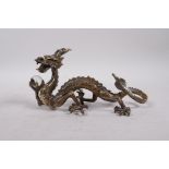A Chinese bronze five toed dragon clutching a glass ball, 8" long
