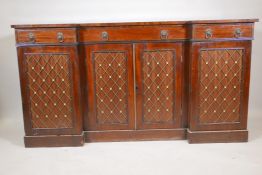 A Regency mahogany breakfront sideboard, the four doors fitted with brass grills, raised on a plinth