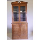 An Edwardian mahogany bookcase, with glazed upper section over two cupboards, raised on a plinth