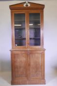 An Edwardian mahogany bookcase, with glazed upper section over two cupboards, raised on a plinth