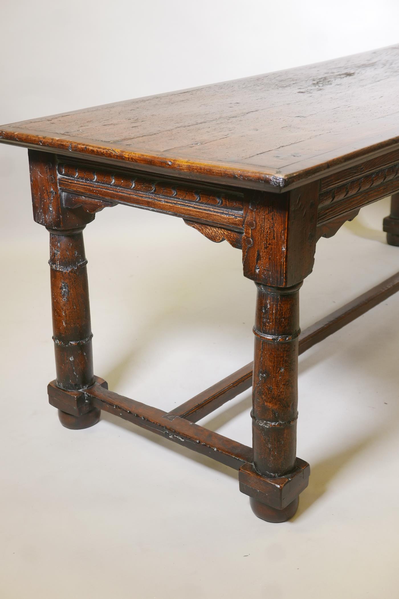 An antique oak refectory table, with plank top and carved frieze raised on gun barrel turned - Image 5 of 9