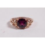 A 14ct rose gold ring set with a garnet and diamonds, approximate size 'N'