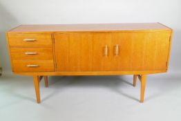 A mid C20th teak sideboard with three drawers and two cupboards, nickel plated handles, bears