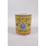 A Chinese yellow ground porcelain brush pot with polychrome lotus flower decoration, seal mark to
