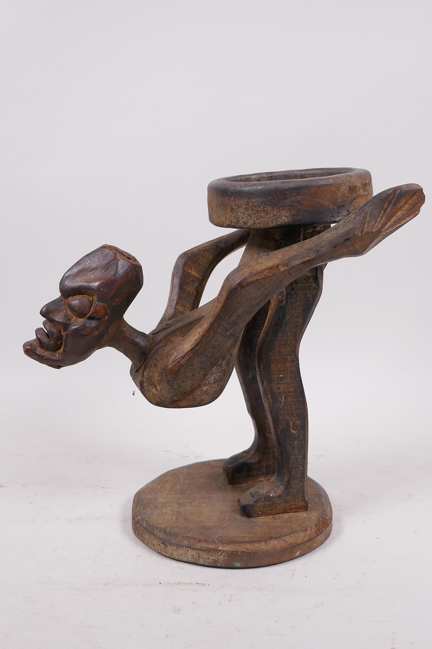An unusual Indonesian wood figure carved as a stand, 9" high