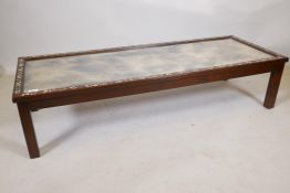 A Chinese hardwood low table, inlaid with mother of pearl decoration, and inset with antiqued mirror