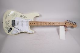 An unused Fender Stratocaster guitar bearing signatures from the band Bon Jovi, 39" long