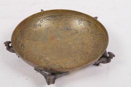 A small engraved brass bowl with Egyptian revival decoration raised on five phoenix supports, made