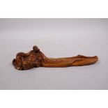 A Chinese carved boxwood incense stick holder in the form of a reclining sage, 7½" long
