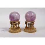 A pair of ormolu stands with lion supports, inset with crystal balls, 4" high