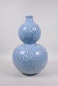 A Chinese light blue glazed porcelain double gourd vase with raised all over gourd vine