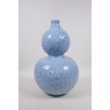 A Chinese light blue glazed porcelain double gourd vase with raised all over gourd vine