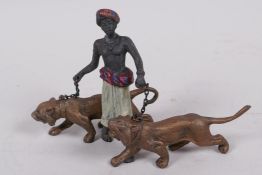 A cold painted bronze figure of an Arab gentleman with two tigers, 3" high