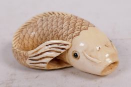 A carved bone netsuke in the form of a carp, signed, 2" long