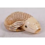 A carved bone netsuke in the form of a carp, signed, 2" long