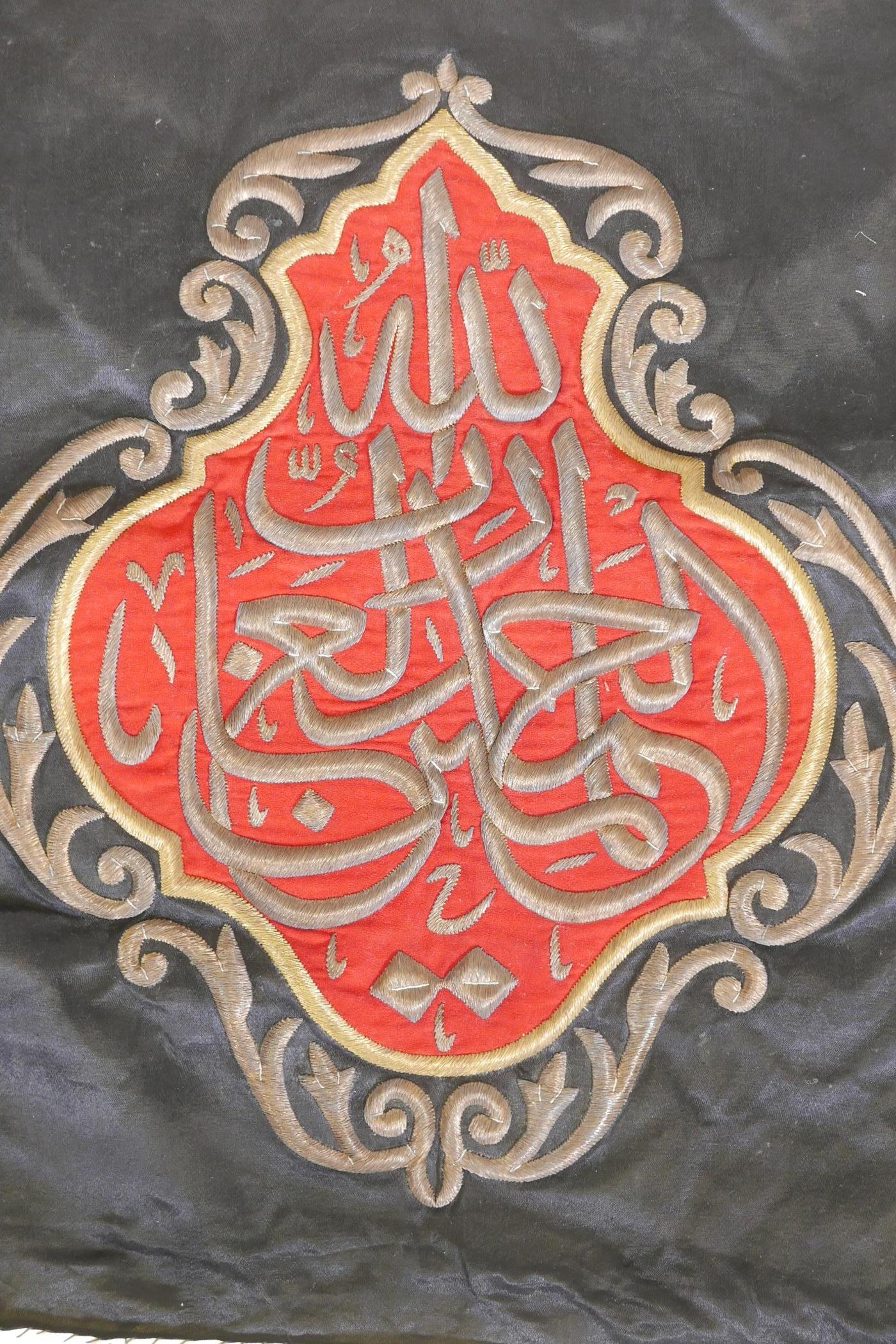 An Islamic wall hanging embroidered with calligraphy in gilt metal wire on a red ground, 32" x 27" - Image 2 of 2