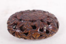 A carved wood okimono hollow carved as flowers with mother of pearl, signed plaque and gold and